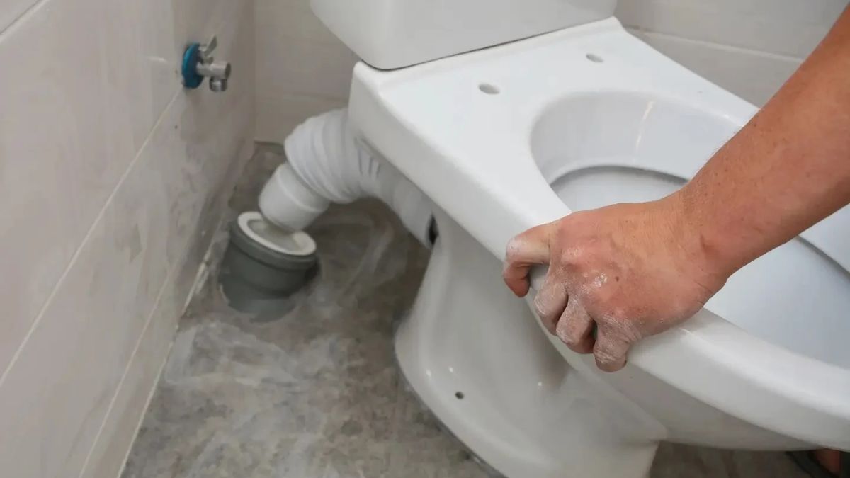 Plumber installing a new toilet in a Lancaster, CA bathroom